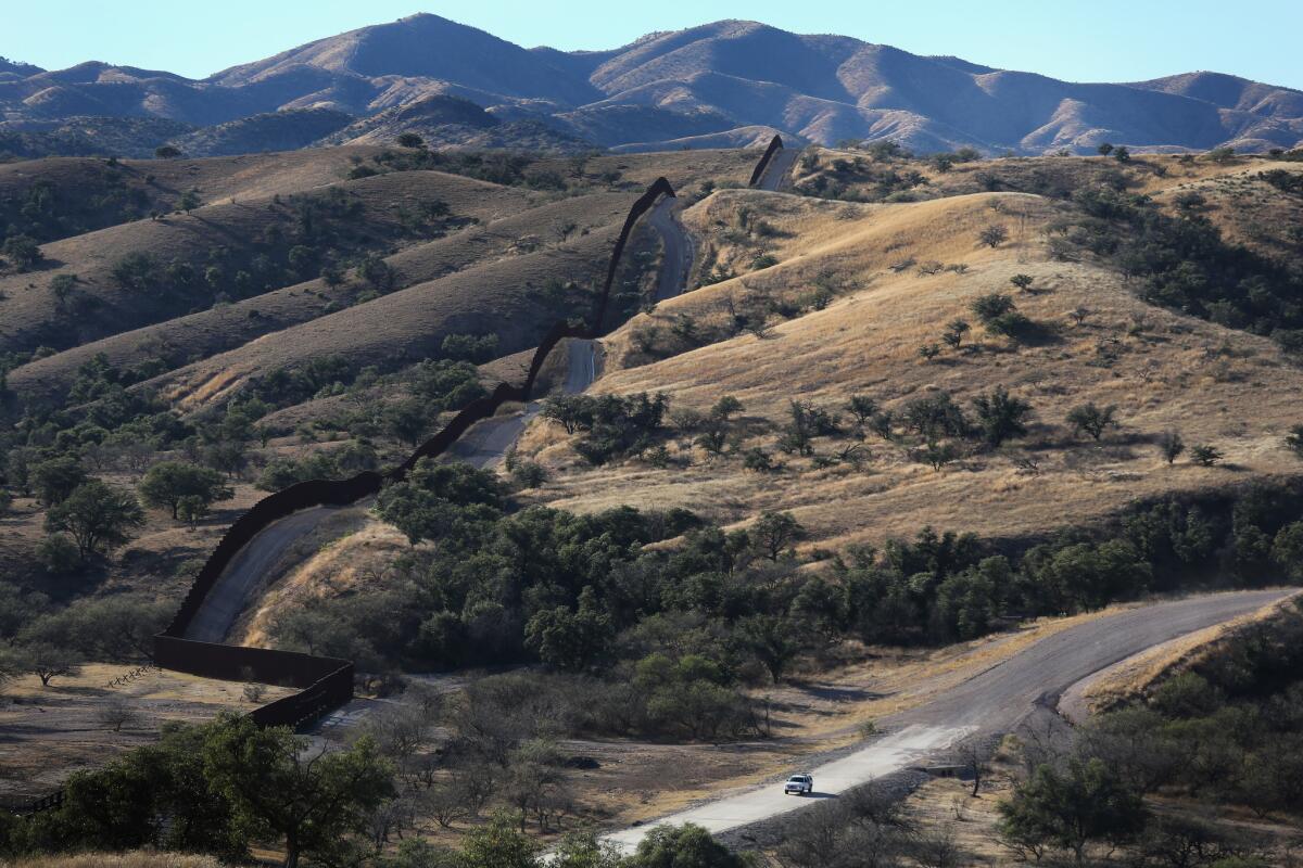 The U.S.-Mexico border fence cuts through the desert near Nogales, Ariz.