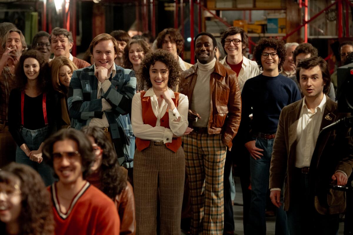 A diverse group of young actors and comedians all facing the camera, smiling