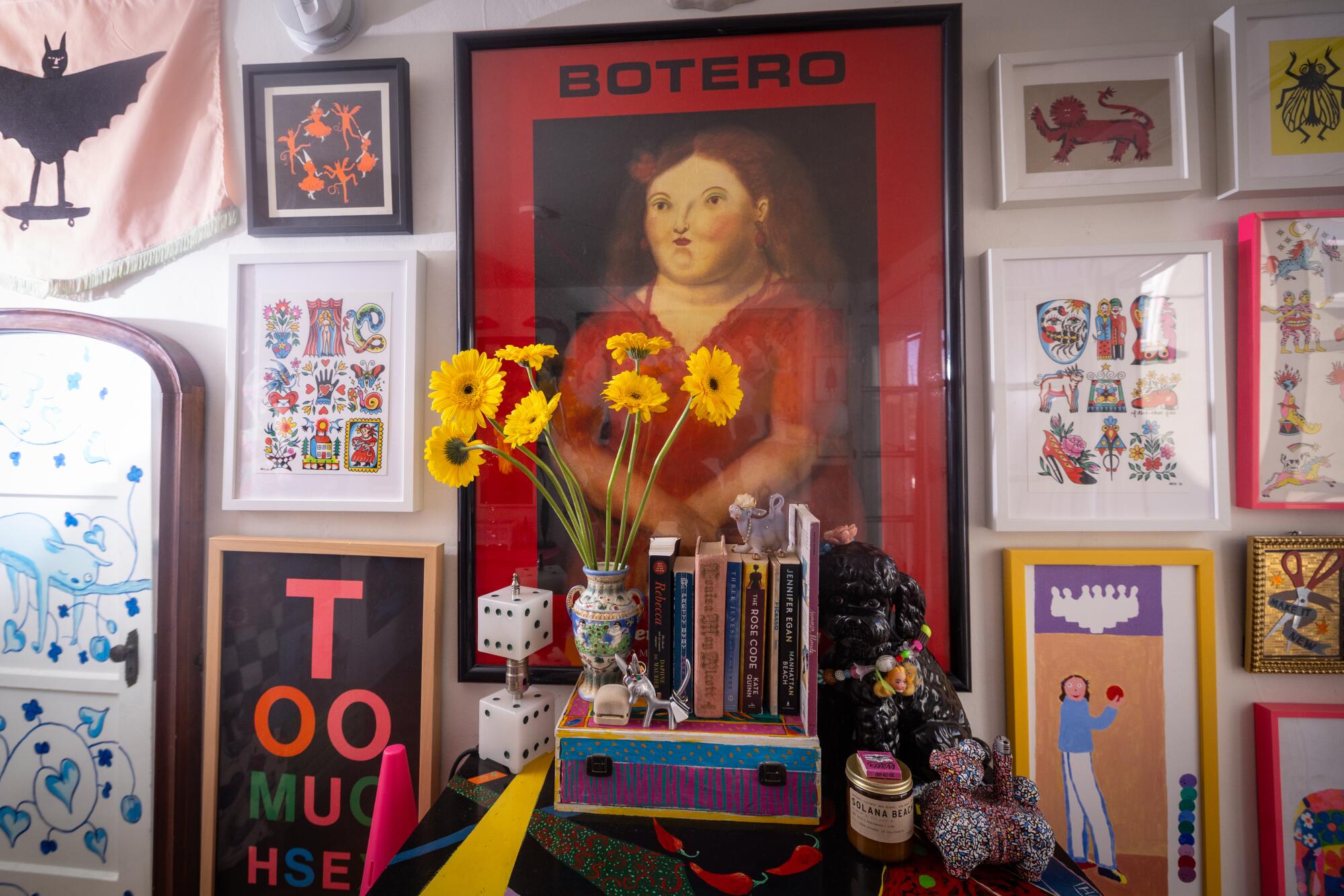 Art, including a woman wearing a red dress, and one that says "Too Much" adorns the bedroom.