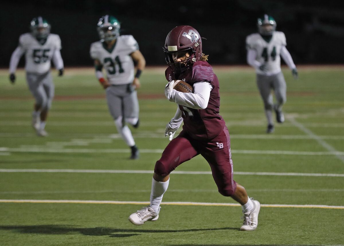 Jackson Rodriguez (11) runs between defenders for a touchdown against Granada Hills on Saturday.
