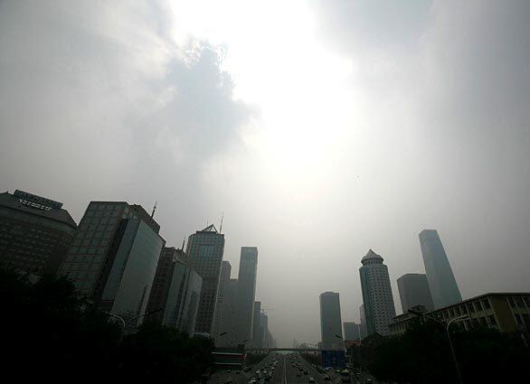 Beijing's central business district is shrouded by smog Monday, just 11 days before the start of the Summer Olympics. State media reported that the Chinese government was considering last-minute emergency measures to curb the pollution.