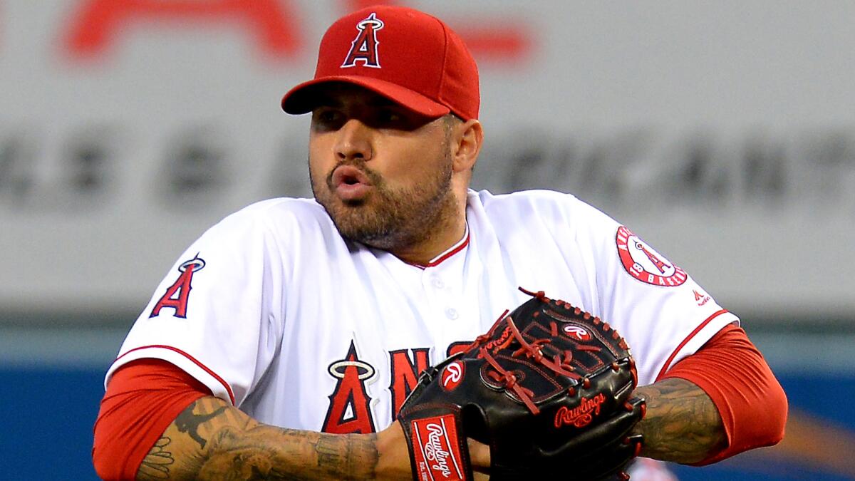 Angels starter Hector Santiago takes a deep breath as Manager Mike Scioscia (not pictured) heads toward the mount to replace him Friday night.