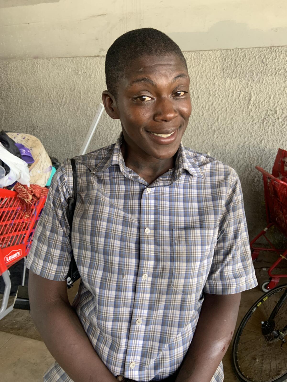 A young Black man sitting outside