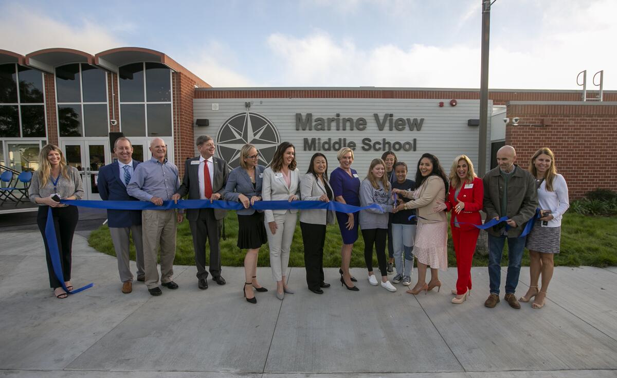 Officials cut a ribbon at the newly reopened Marine View Middle School on Monday.