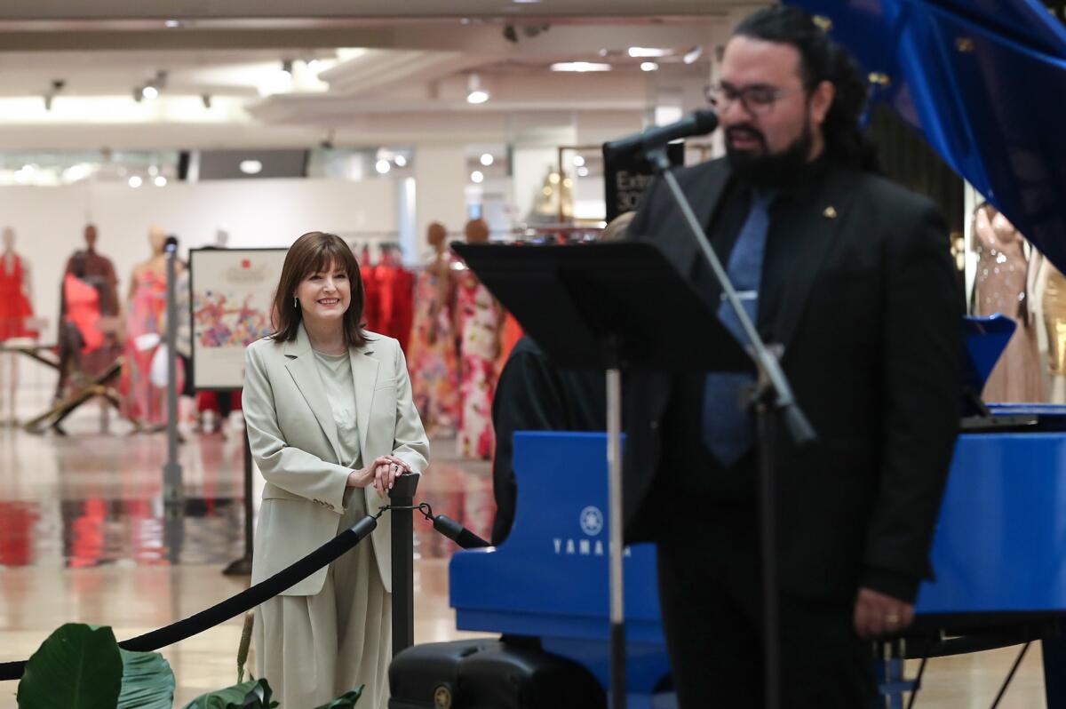 Michelle Vacca listens to vocalist Abraham Cervantes from Pacific Chorale at South Coast Plaza.