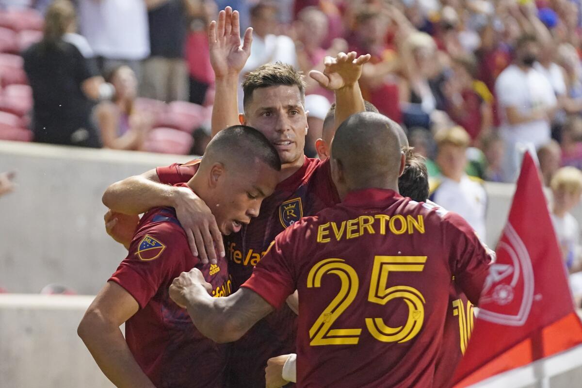 Real Salt Lake's Everton Luiz (25) and Damir Kreilach, rear, congratulate Bobby Wood, left, after his goal against Austin FC during the first half of an MLS soccer match Saturday, Aug. 14, 2021, in Sandy, Utah. (AP Photo/Rick Bowmer)