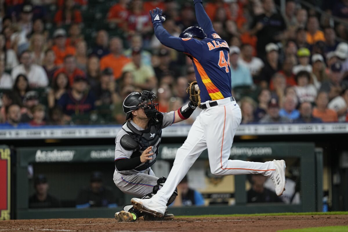 Houston Astros' Yordan Alvarez (44) is tagged out by Miami Marlins catcher Nick Fortes during the seventh inning of a baseball game Sunday, June 12, 2022, in Houston. (AP Photo/David J. Phillip)