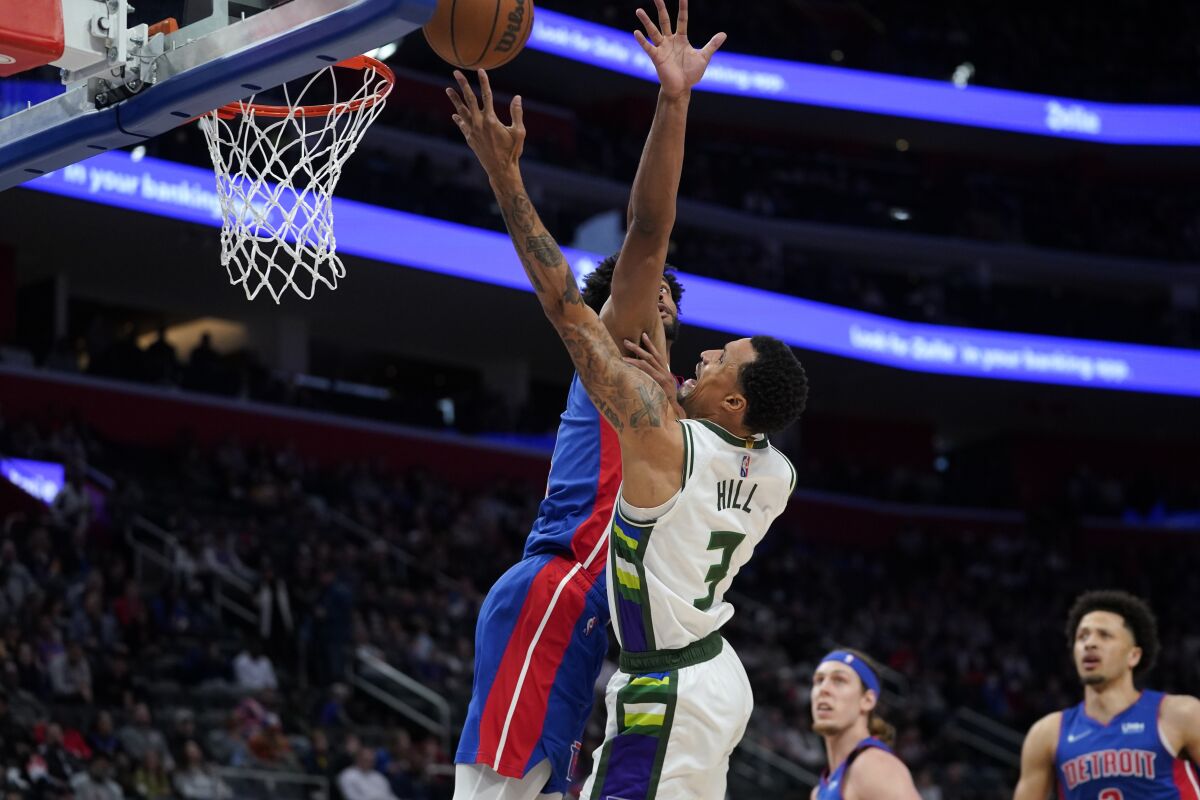 Milwaukee Bucks guard George Hill (3) drives on Detroit Pistons' Braxton Key in the first half of an NBA basketball game in Detroit, Friday, April 8, 2022. (AP Photo/Paul Sancya)