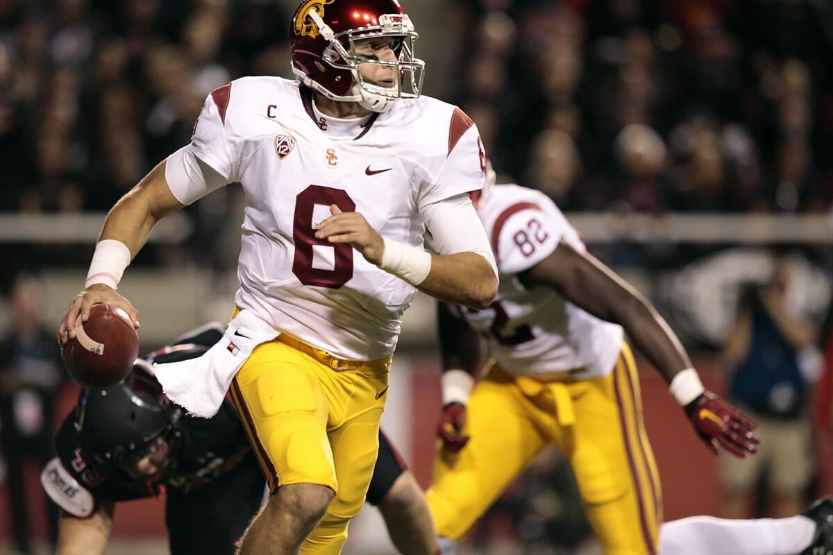Trojans quarterback Cody Kessler scrambles from the pocket as he looks downfield for a receiver in the first quarter.
