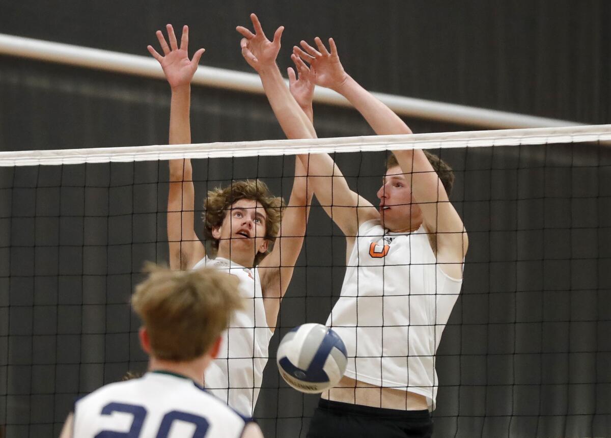 Huntington's Camden Schulte (30) and Michael Rini (6) block a kill attempt against Carlsbad La Costa Canyon on Tuesday.