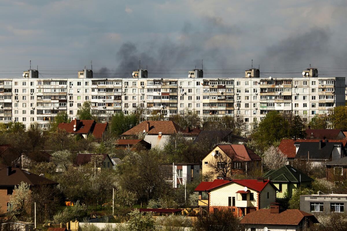Smoke rises over a residential area of a large city 