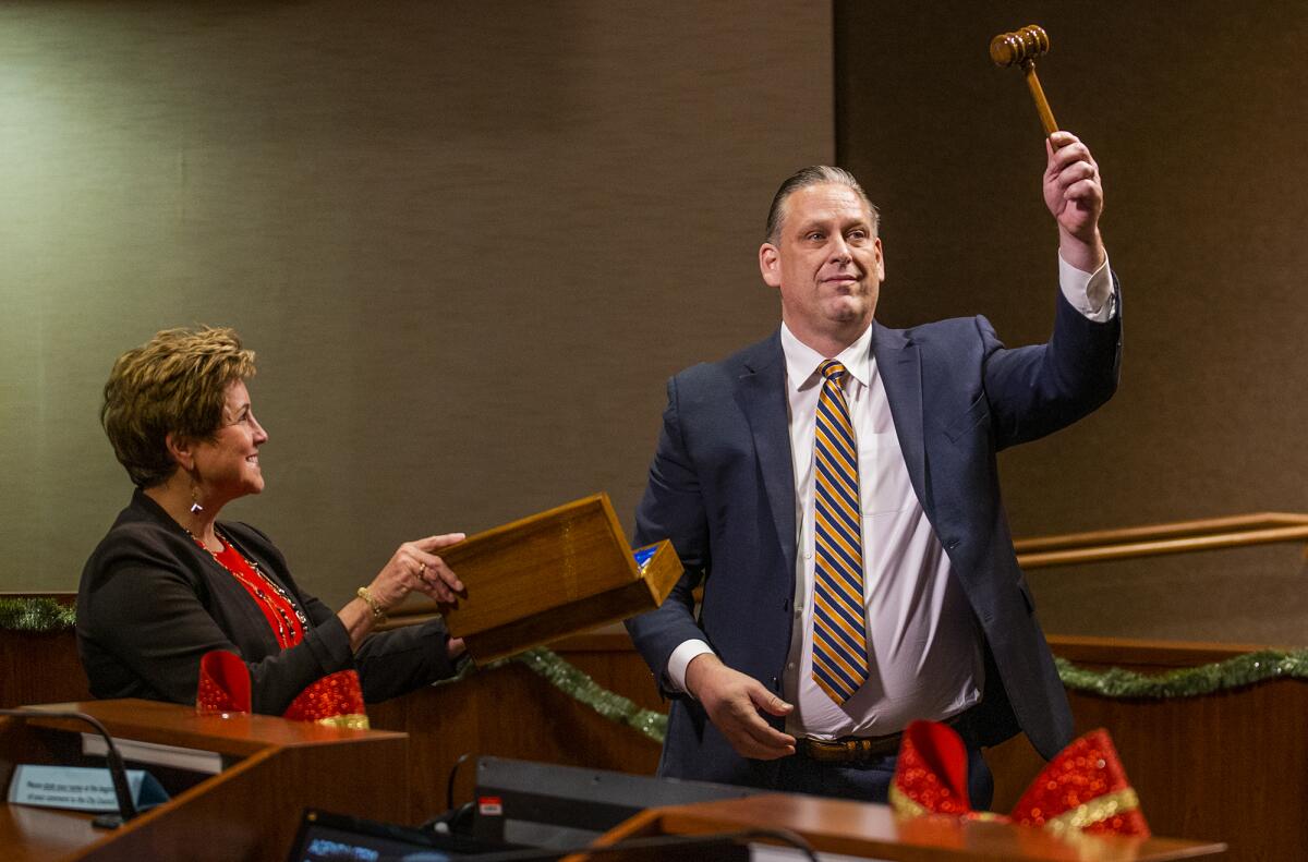 Outgoing Mayor Barbara Delgleize presents the gavel to newly selected Huntington Beach Mayor Tony Strickland.