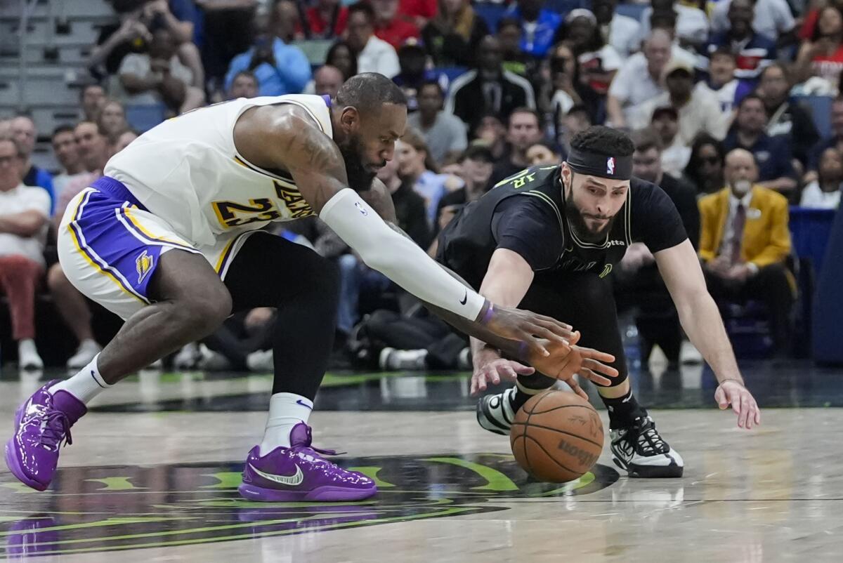 Pelicans forward Larry Nance Jr. battles for a loose ball against LeBron James in the second half.