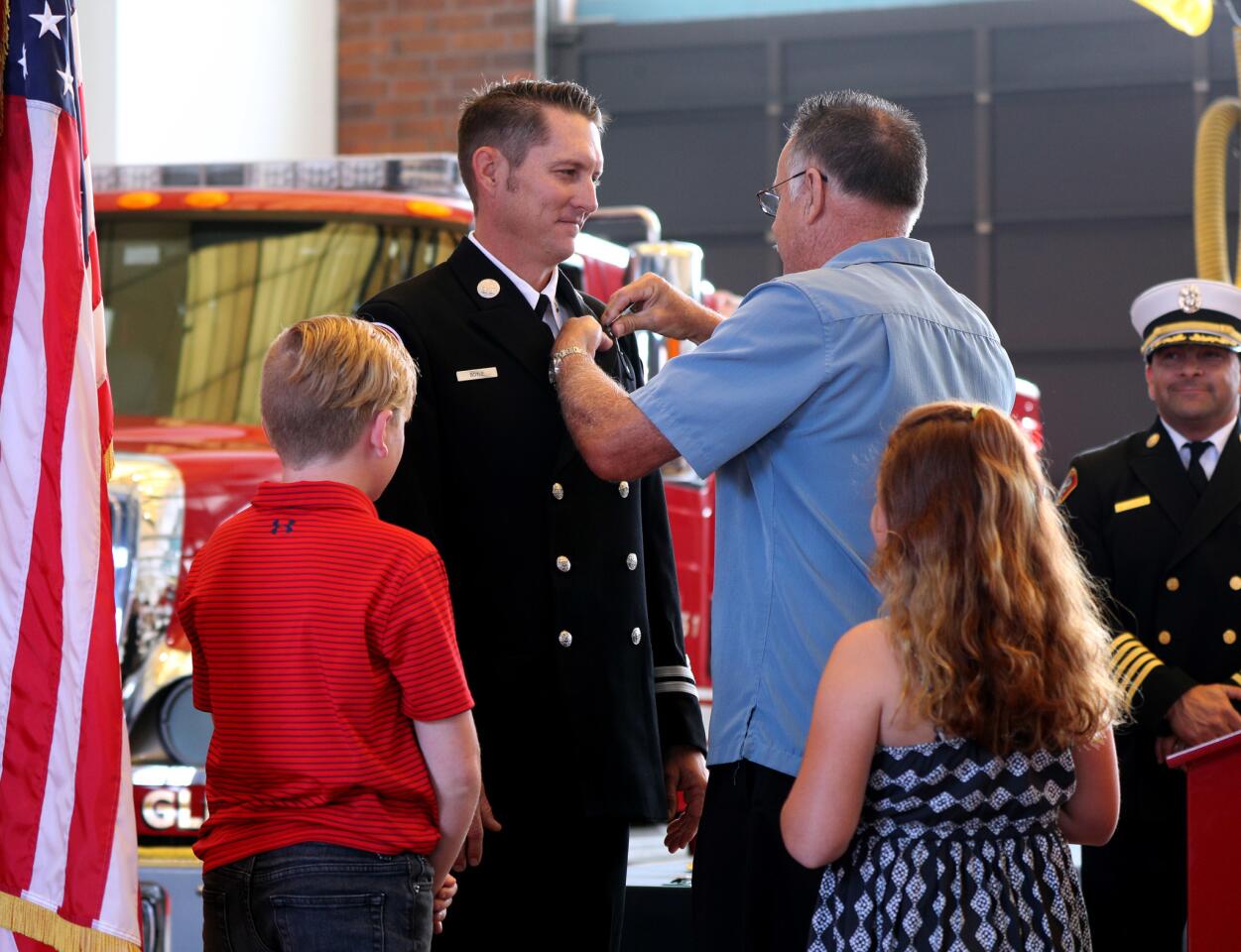 Newly-promoted Glendale Fire Dept. captain Brad Boyle gets pinned by his father Jim Boyle as his children Braxton, left, and Brielle, right, look on during Promotion Ceremony at Station 21, in Glendale on Thursday, June 6, 2019. Eight fire dept. personnel were elevated in rank.