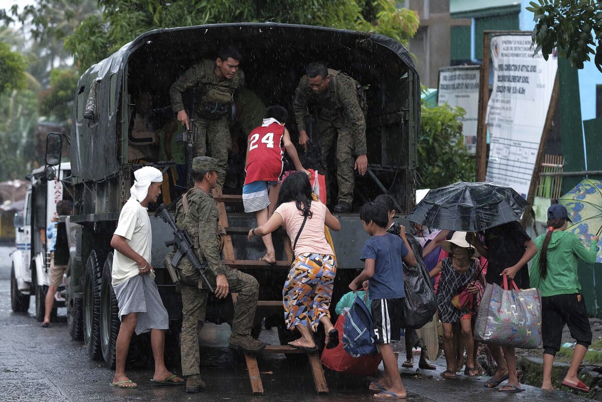 Residents ride a military truck as they evacuate to safer grounds in preparation for the coming of Typhoon Kammuri in Legazpi, Albay province, southeast of Manila, Philippines on Monday Dec. 2, 2109. The Philippines' main island, including the national capital, Manila, is under a tropical cyclone warning for a typhoon forecast to hit Monday night into Tuesday. (AP Photo)