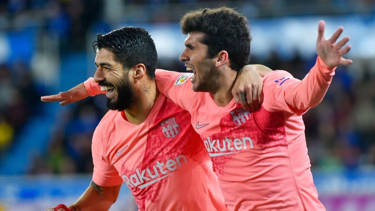 Barcelona teammates Luis Suarez, left, and Carles Alena celebrate after a goal against Deportivo Alaves on April 23.