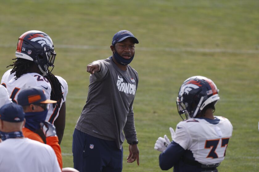 Denver Broncos defensive backs coach Renaldo Hill takes part in drills.