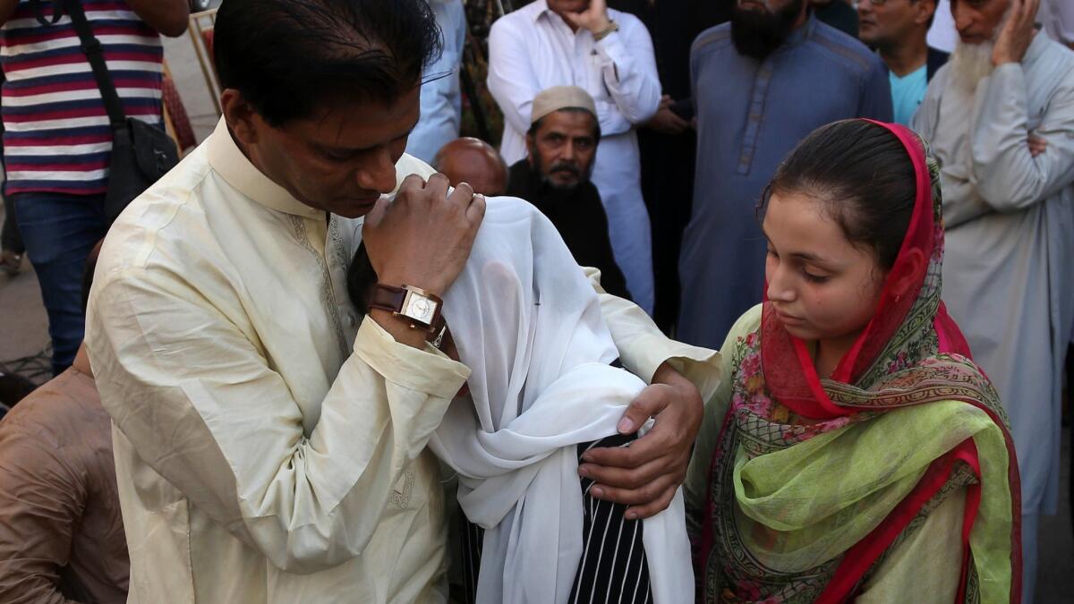 Abdul Aziz Sheikh, father of Sabika Sheikh, comforts relatives.