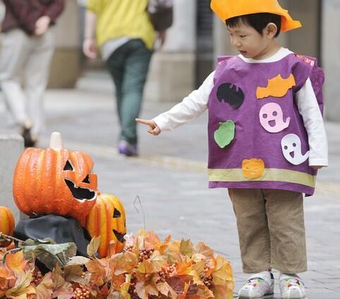 A boy plays with a pumpkin display at the Marunouchi shopping district in central Tokyo.
