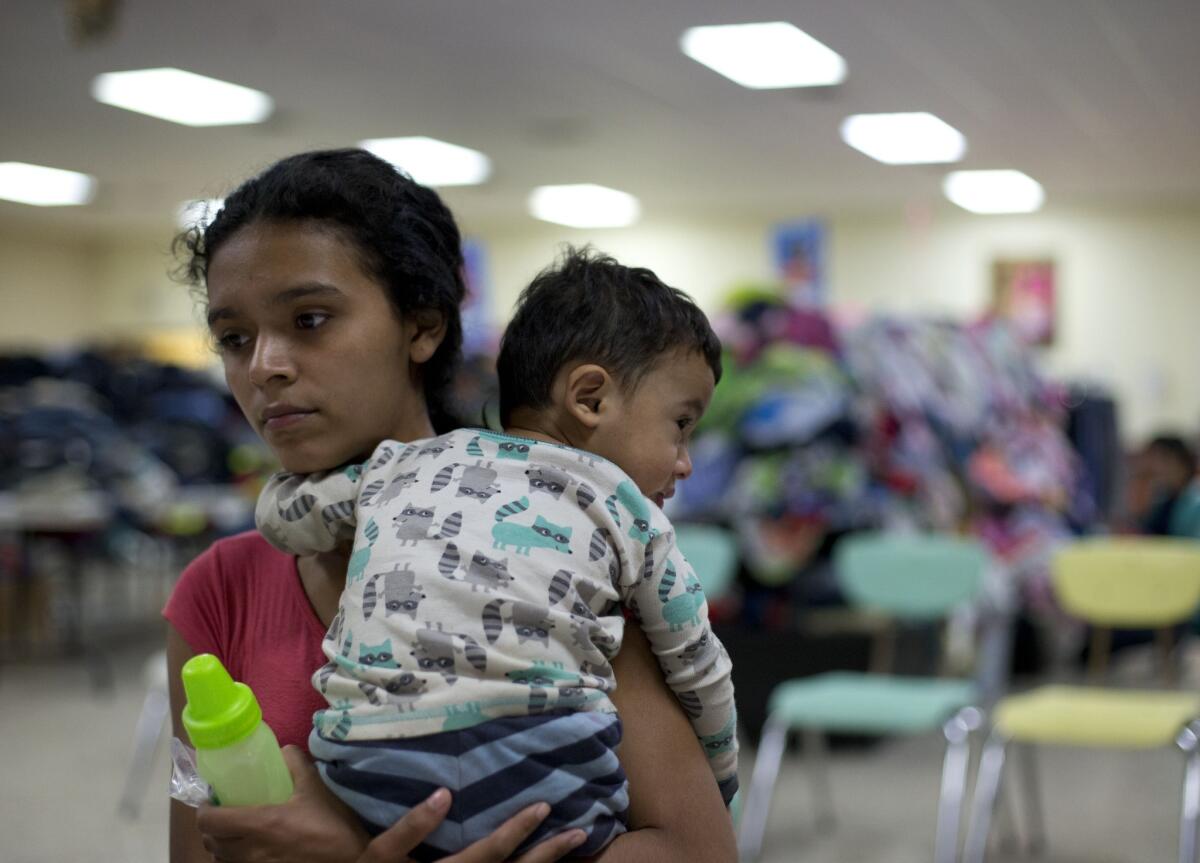 Rose Danubia Maldonado, 18, of Honduras, holds her 14-month-old son, Miguel Yahyr Padilla, as she receives instructions on how to use the bus system at a migrant assistance center at Sacred Heart Catholic Church in McAllen, Texas.