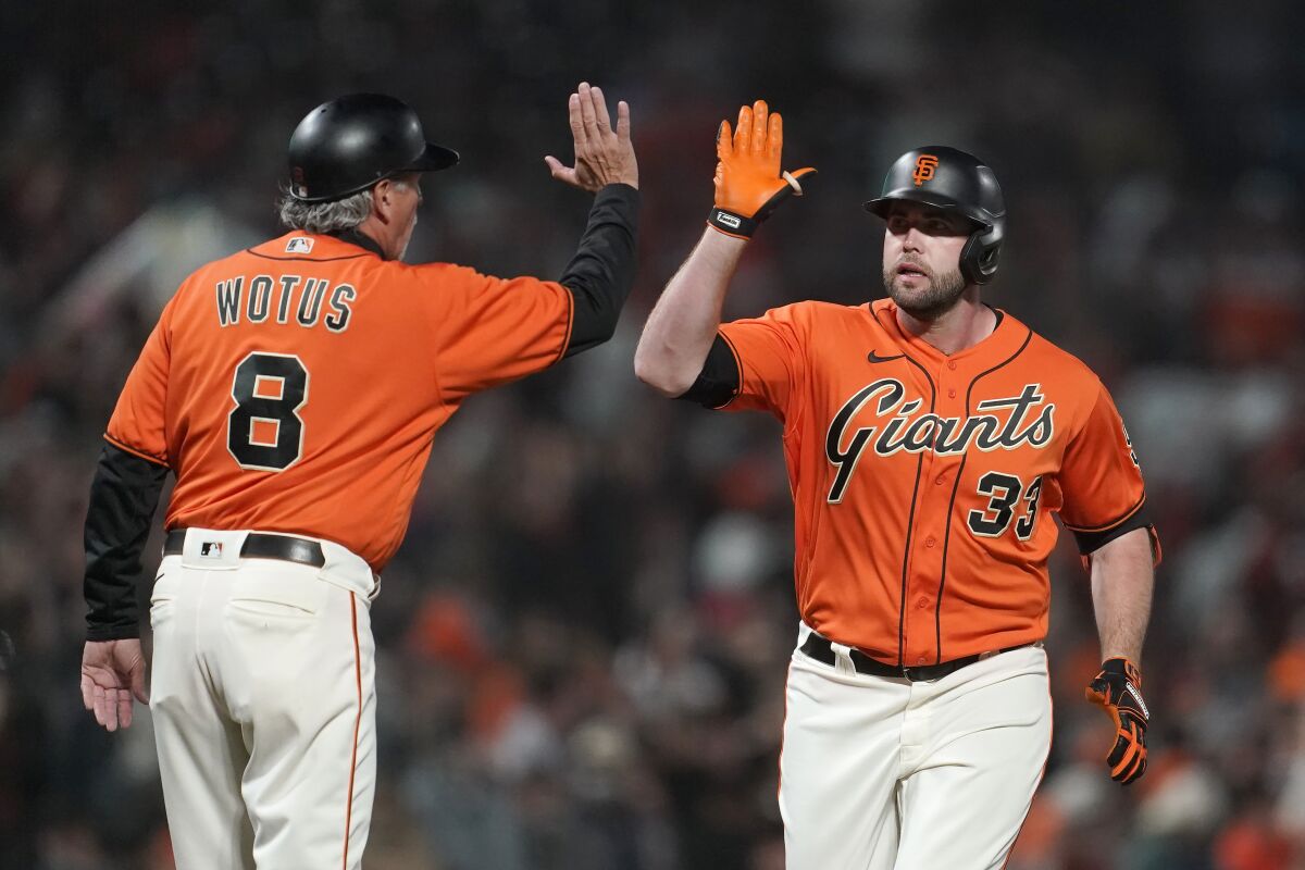 San Francisco Giants' Darin Ruf, right, is congratulated by third base coach Ron Wotus after hitting a home run against the San Diego Padres during the first inning of a baseball game in San Francisco, Friday, Oct. 1, 2021. (AP Photo/Jeff Chiu)