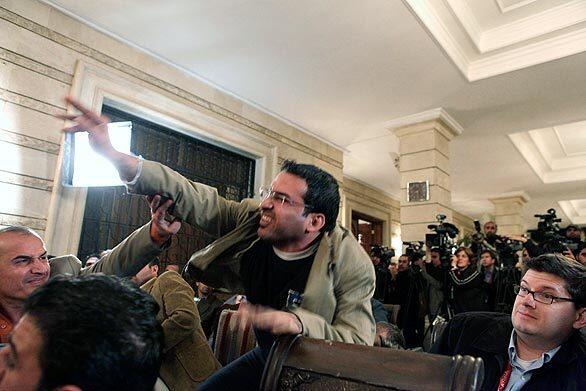 Muntather Zaidi throws a shoe at President George W. Bush during a news conference with Iraqi Prime Minister Nouri Maliki in Baghdad. The man threw two shoes at Bush, one after another, during the news conference. Bush ducked both throws.