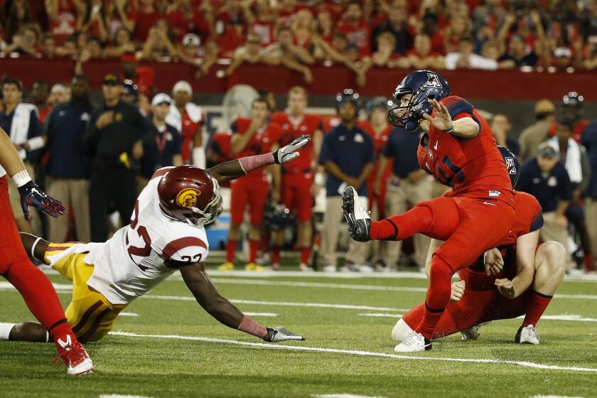 Arizona kicker Casey Skowron misses a 36-yard field-goal attempt in front of USC safety Leon McQuay in the closing seconds of the Trojans' 28-26 victory Saturday.