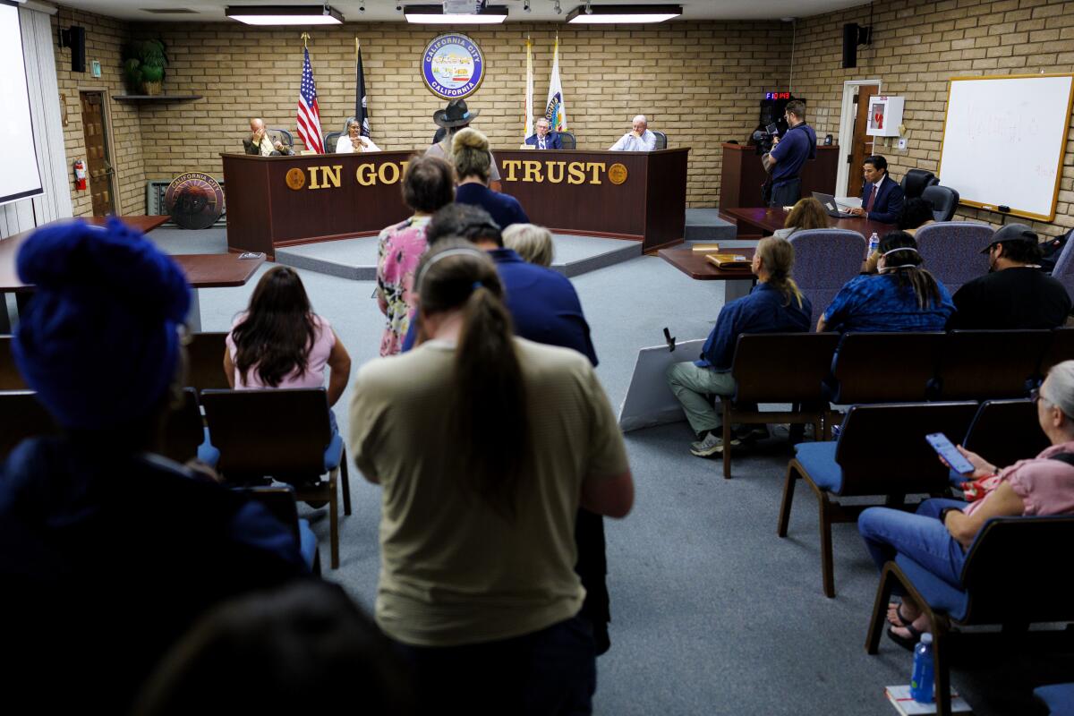 Residents stand in line to speak out against the California Correctional Facility housing migrants