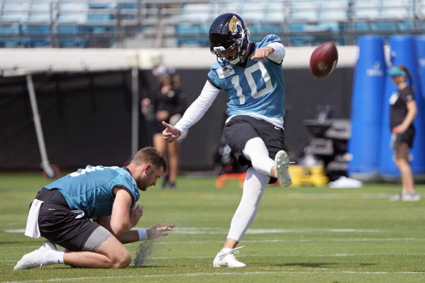 Jacksonville Jaguars kicker Brandon McManus (10) works on field goals as Logan Cooke holds during an NFL football practice, Tuesday, May 30, 2023, in Jacksonville, Fla. (AP Photo/John Raoux)
