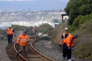 SAN CLEMENTE CA JANUARY 25, 2024 - Workers in San Clemente continue to clear the tracks following a landslide in San Clemente that occurred on Wednesday, Jan. 24. Passenger rail service between the Laguna Niguel/Mission Viejo and Oceanside stations remained suspended due to a landslide that again sent boulders and debris onto the tracks and damaged the Mariposa Trail Bridge in San Clemente. (Allen J. Schaben / Los Angeles Times)