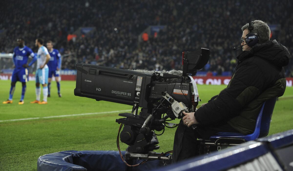 FILE - A view of TV camera during the English Premier League soccer match between Leicester City and Newcastle United at the King Power Stadium in Leicester, England, March 14, 2016. For the first time since the Premier League began 30 years ago, more cash will be generated from overseas broadcasters for the next three seasons than for domestic rights. Clubs were informed by the league at a meeting of top executives on Thursday, Feb. 10, 2022 that it projects 5.3 billion pounds ($7.2 billion) will be generated from foreign rights once deals are concluded, up from 4.1 billion pounds in the current three-season cycle. (AP Photo/Rui Vieira, File)