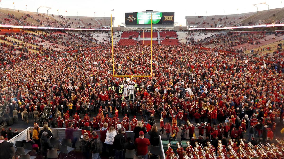 Iowa State fans celebrate on the field Saturday after the Cyclones handed TCU its first loss.