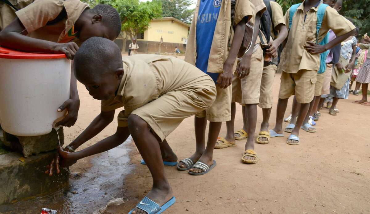 Children wait in line to wash their hands on Oct. 23 at a school in Bouake, Ivory Coast, which is currently free of the Ebola epidemic ravaging its neighbors and has launched a hunt for a Guinean health worker who may have fled his home country after possibly catching the disease.