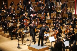 Conductor Gustavo Dudamel and trumpeter Thomas Hooten performing onstage with the L.A. Philharmonic orchestra