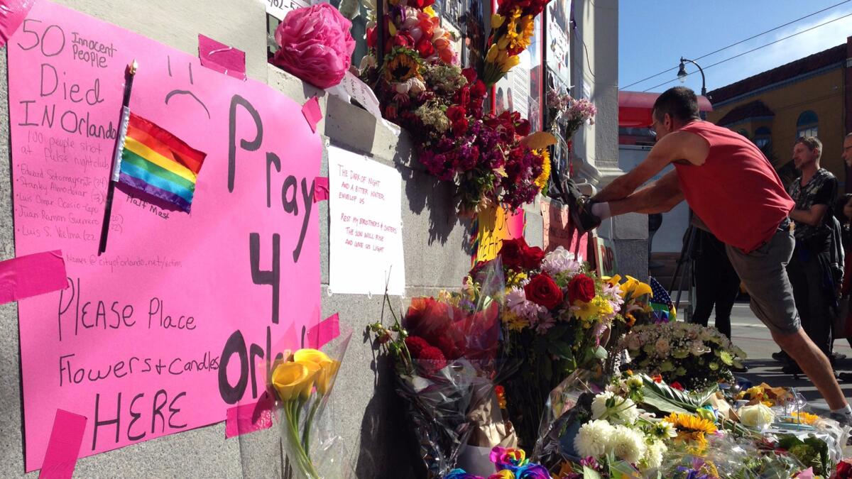 Brian Levitt, 56, retapes a memorial sign for the Orlando victims in San Francisco's Castro District. The sign says in Spanish, "For our fallen brothers and sisters in Orlando." Levitt said: "It's an attack on every one of us."