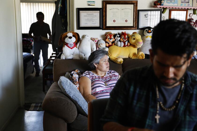 SANTA ANA, CALIFORNIA: Jonatan Gutierrez, 32, right, and his parents Rocio Urzua, 54, center, and Pablo Gutierrez, 65, at left, are photographed at home in Santa Ana, California on Friday, July 2, 2021. Medi-Cal expansion will offer relier to income eligible adults 50 and older regardless of immigration status. (Christina House / Los Angeles Times)