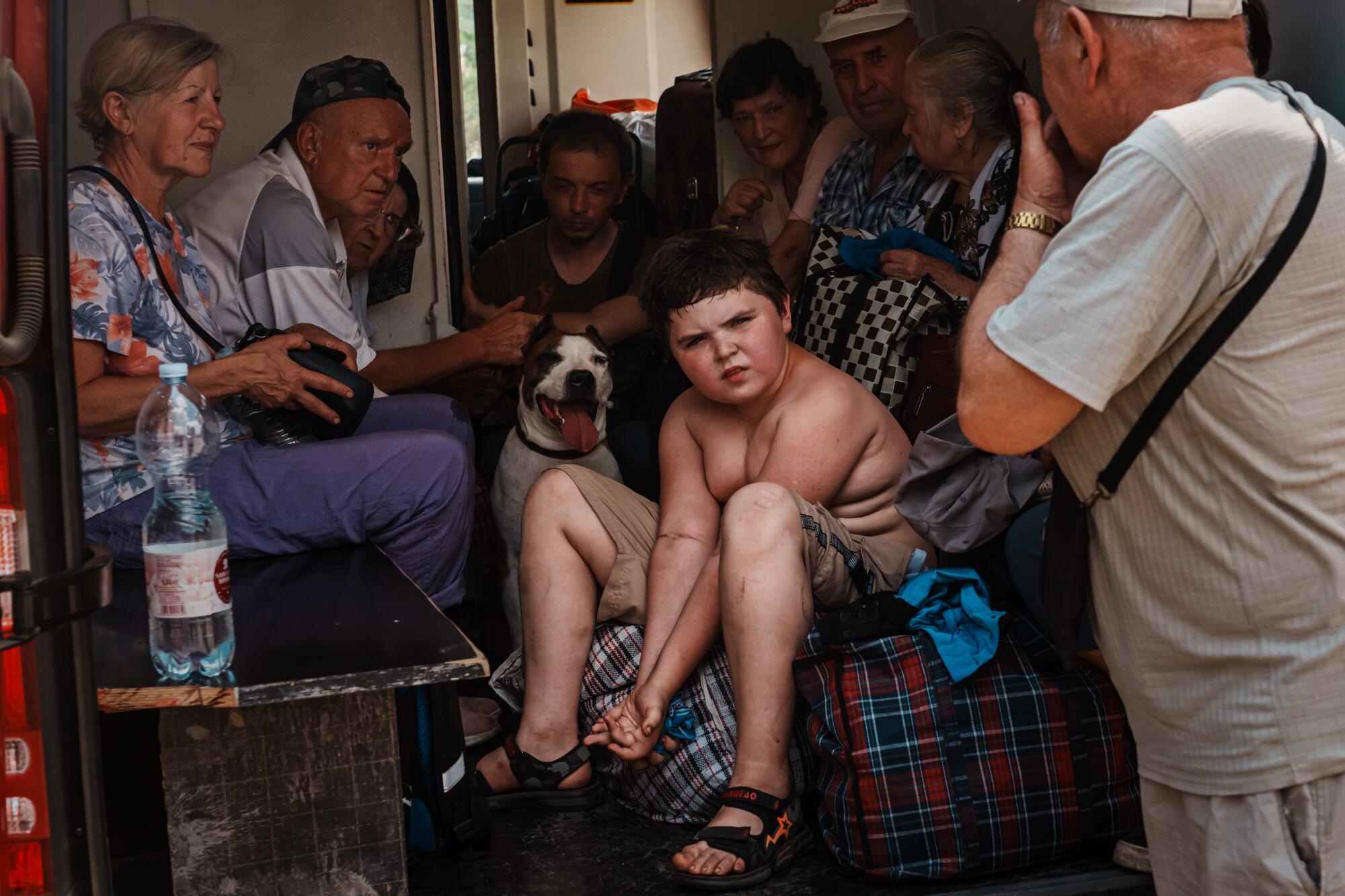 Residents of Lysychansk rests as they endure the heat and the bumpy journey during an evacuation