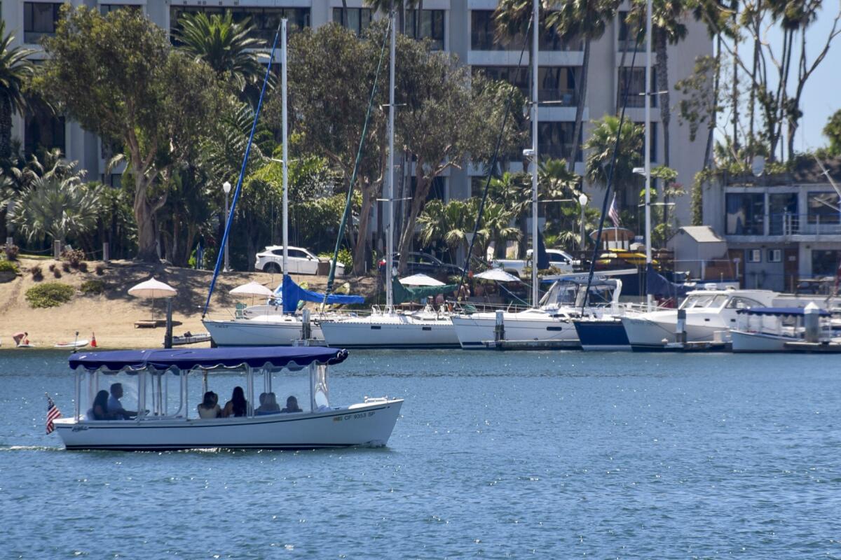 A photo of a Duffy boat coasting in the harbor at Newport Beach.