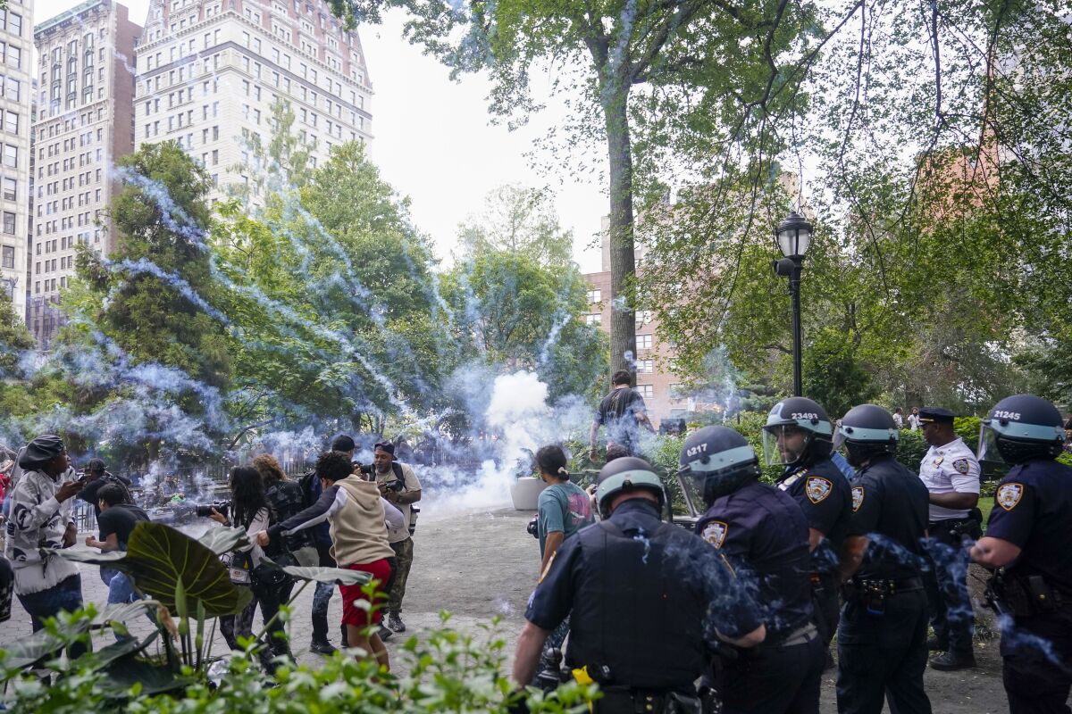 Policas detonan una bomba de humo para dispersar a una multitud, el viernes 4 de agosto de 2023, en Union Square, Nueva York. (AP Foto/Mary Altaffer)