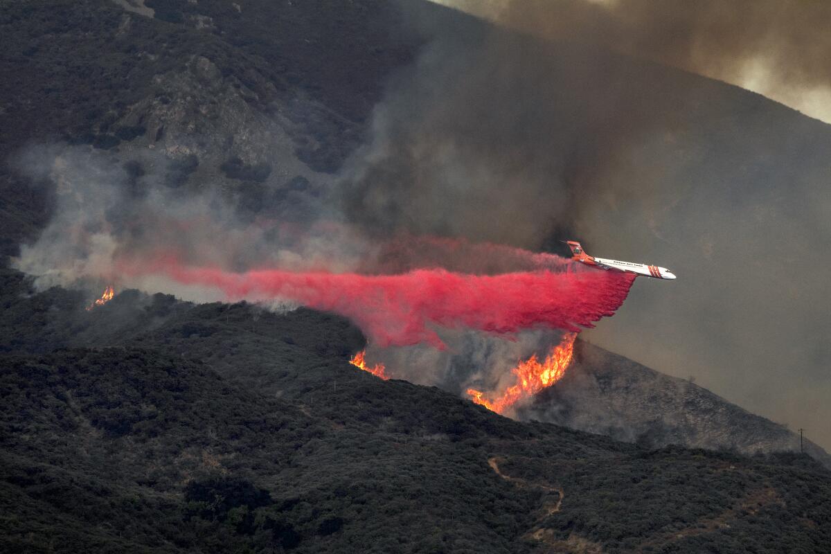 An Erickson Aero Tanker makes a retardant drop on the Airport fire burning in Trabuco Canyon.