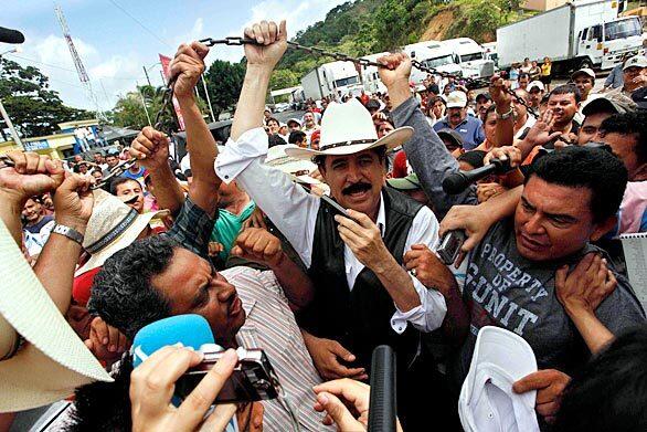 Ousted President Manuel Zelaya, surrounded by supporters and the press in Las Manos, Nicaragua, lifts the chain along the border with Honduras in Las Manos. Zelaya's supporters flocked to the remote border between Honduras and Nicaragua to support his bid to reclaim the presidency from the government that ousted him in a June 28 coup.