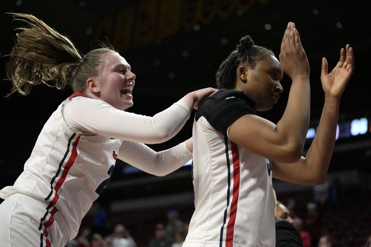 Dayton guard Erin Whalen, left, celebrates with teammate Tenin Magassa, right, after a First Four game against DePaul in the NCAA women's college basketball tournament, Wednesday, March 16, 2022, in Ames, Iowa. Dayton won 88-57. (AP Photo/Charlie Neibergall)
