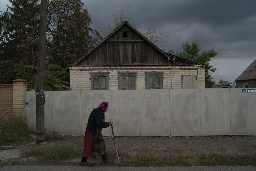 An elderly woman walks on a street in Raihorodok, Ukraine, Monday, Sept. 26, 2022. (AP Photo/Leo Correa)