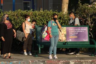 VAN NUYS, CA -SEPTEMBER 1, 2022: People wait for the Metro bus to arrive at a bus stop with no shade on Sepulveda Blvd. in Van Nuys.The city is about to contract for new shade and there's a big push among activists to do better. (Mel Melcon / Los Angeles Times)