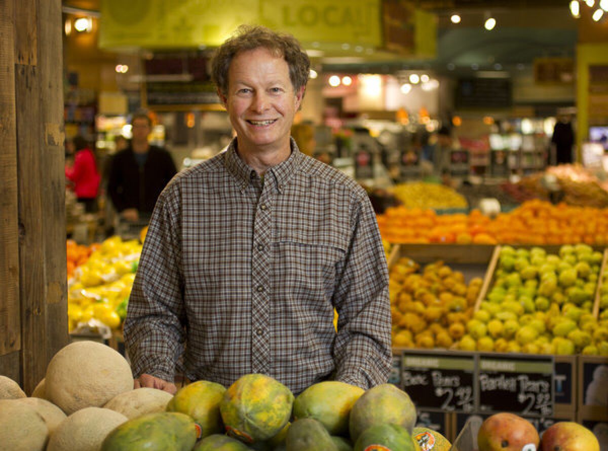 John Mackey, CEO of Whole Foods, in the produce section of a market.