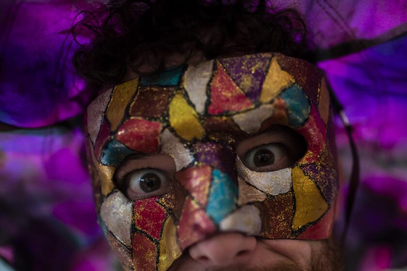A masked reveler participates in a street pre-carnival party by the "Cordao do Boitata" Block, in Rio de Janeiro, Brazil, Sunday, Feb. 12, 2023. Revelers are taking to the streets for the open-air block parties, leading up to Carnival's official Feb. 17th opening. (AP Photo/Bruna Prado)