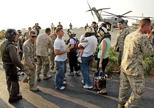 American citizens in Beirut line to up to get fitted with protective gear before they board a U.S. Marine helicopter to take them to Cyprus.