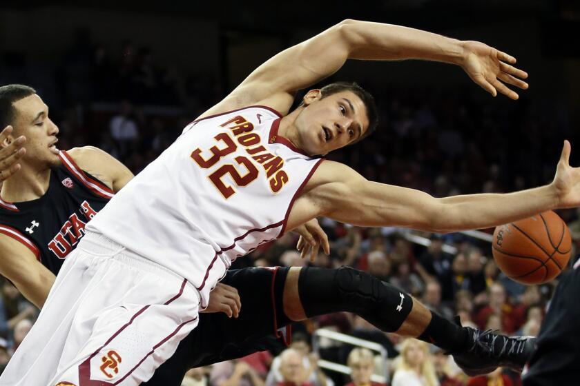 USC forward Nikola Jovanovic loses the ball after Utah's Brekkott Chapman, left, blocked his shot during the second half Sunday.