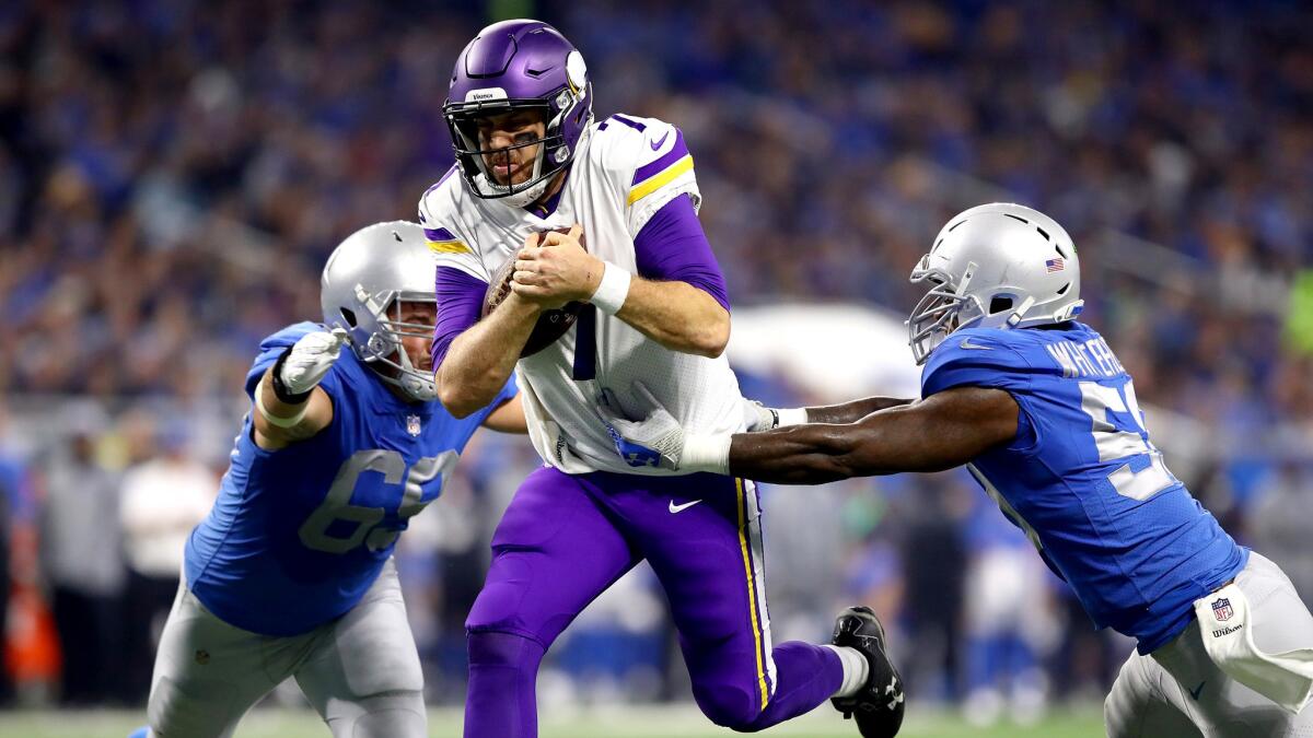 Vikings uarterback Case Keenum slips between Lions defenders Anthony Zettel (69) Tahir Whitehead for a touchdown during the first half Thursday.
