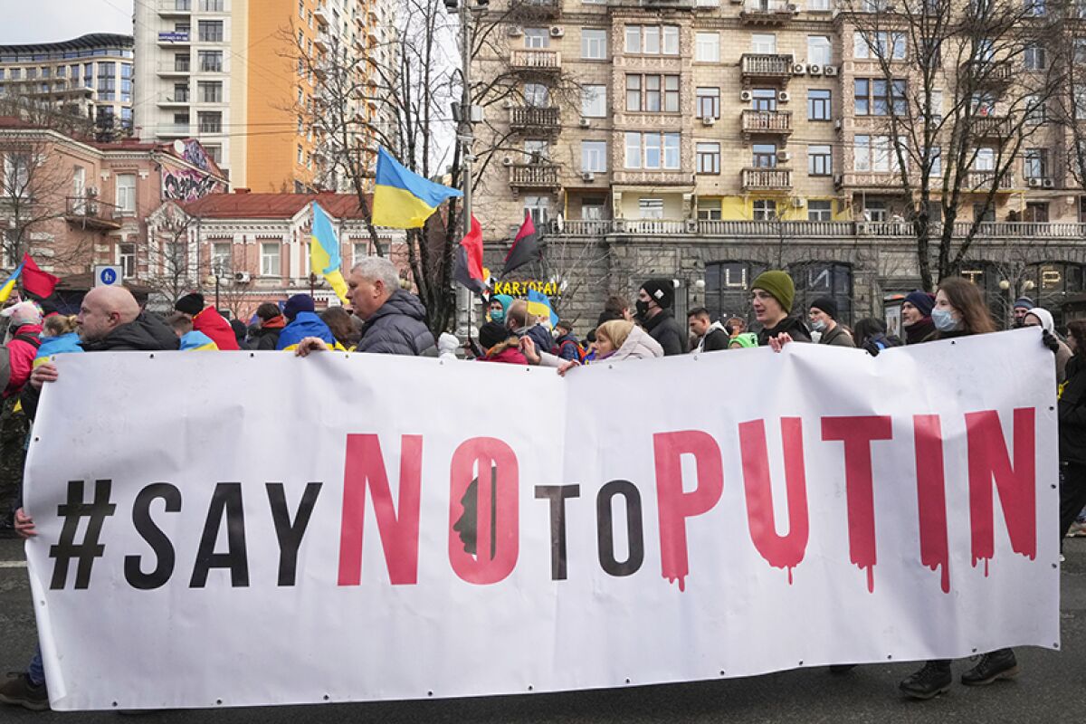 Ukrainians hold a banner that says "Say no to Putin."